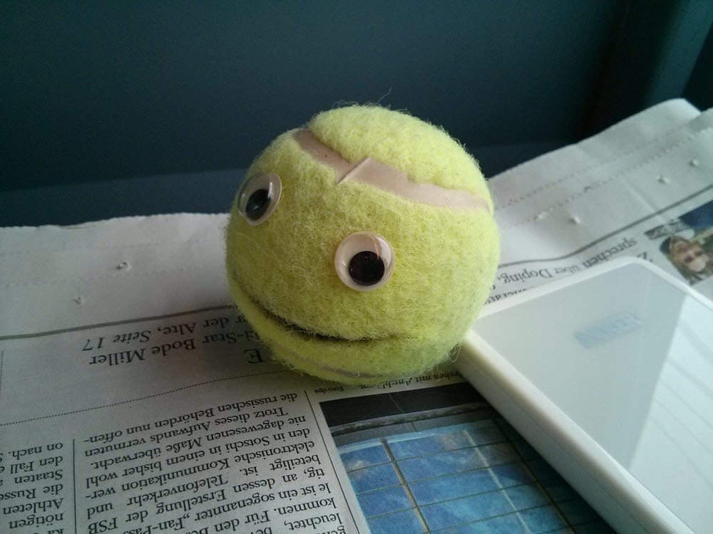 Lustiger Tennisball mit Augen auf einem Schreibtisch.