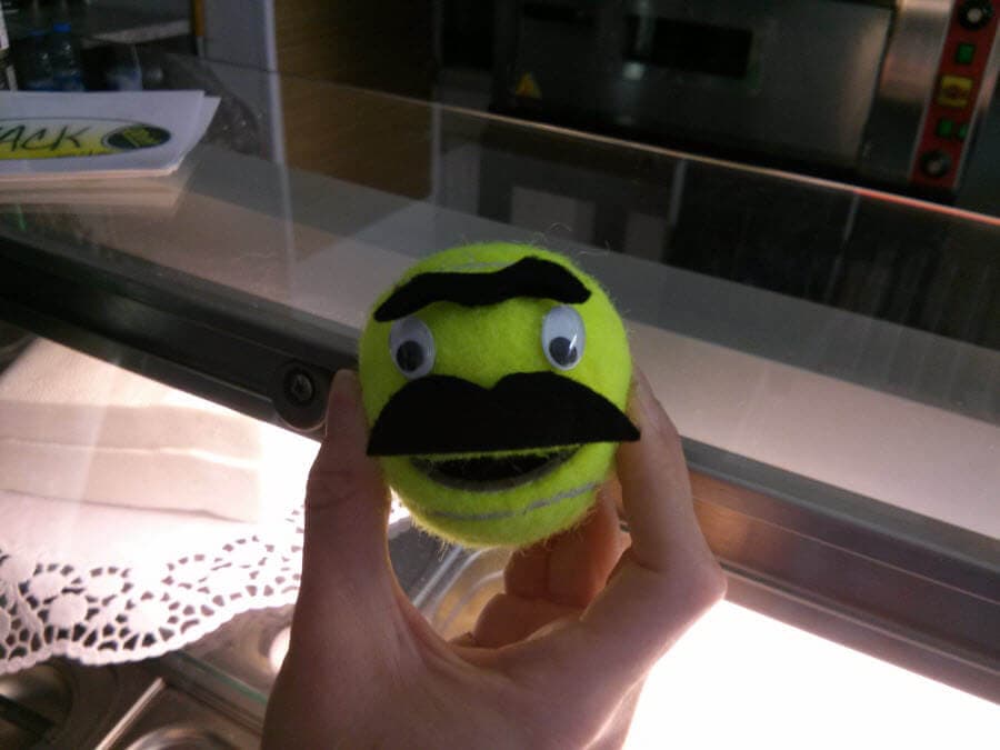 Ball-Kun mit Augen, Mund und Schnurrbart, handgehalten vor Ofen.