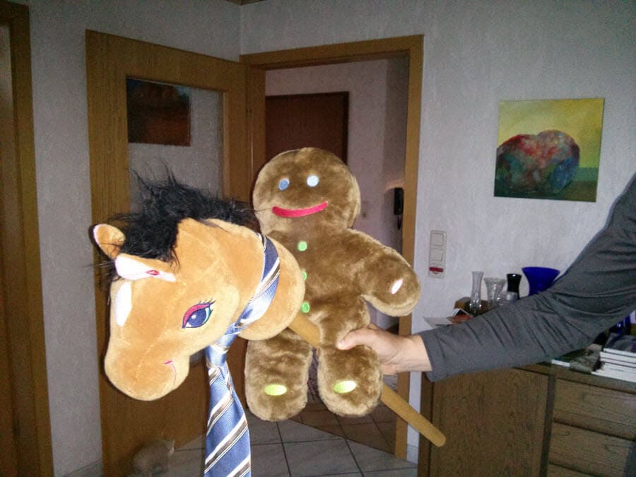 Zwei bunte Bälle, ein Pferd und ein Lebkuchenmann in einem Raum.