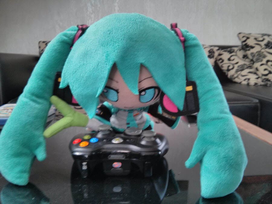 Plüschfiguren von Miku mit Gaming-Controller.
